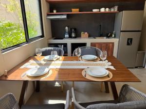 a dining room table with plates and glasses on it at Luxury Tulum Condo Near the Beach in Tulum