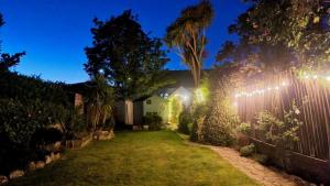 un jardín por la noche con luces en una valla en Springfield, en Milford on Sea