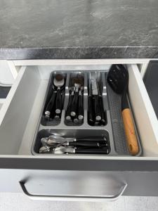 a drawer filled with utensils in a kitchen at Casa WEEK Dunare in Baziaş