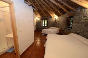 a bedroom with two beds in a stone building at El Rincón del Cuco in Tejedo de Ancares +23 photos