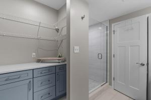 a bathroom with blue cabinets and a shower at Uptown Elegant Escape | JZ Vacation Rentals in Tower Grove +43 photos