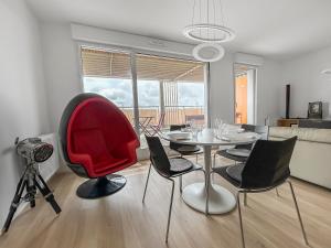 una sala da pranzo con tavolo e sedia rossa di T2 Lumineux - Proche Plage & Technopôle - Parking Privé, Bureau & Wifi Rapide a Brest