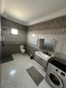 a bathroom with a sink and a washing machine at Villa Line Midoun sans vis-à-vis in Taguermess