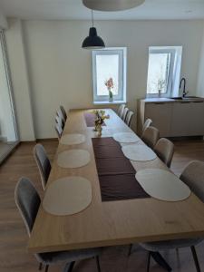 Una sala de conferencias con una larga mesa de madera y sillas. en Villa Hrachovo, 