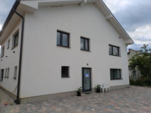 un edificio blanco con ventanas negras y patio en Villa Hrachovo, 