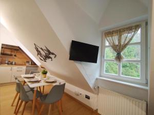 a dining room with a table and a window at Apartament Górska Przystań - Willa Marysin in Bukowina Tatrzańska