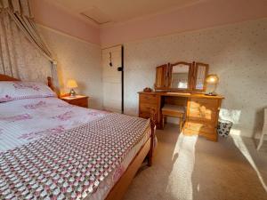 ein Schlafzimmer mit einem Bett, einer Kommode und einem Spiegel in der Unterkunft Charming Lilac Cottage, Aldbrough, East Yorkshire in Aldbrough