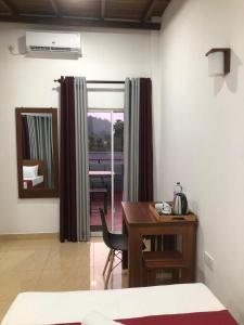a room with a desk and a table and a mirror at Kandy Home Stay in Kandy