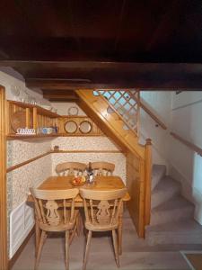 einen Holztisch und Stühle in einem Zimmer mit einer Treppe in der Unterkunft Charming Lilac Cottage, Aldbrough, East Yorkshire in Aldbrough + 8 Fotos