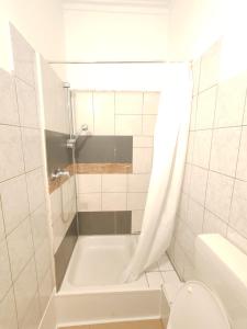 ein weißes Badezimmer mit Badewanne und Toilette in der Unterkunft Stylish 1-Bedroom Apartment for Rent - Central Essen Location in Essen