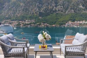 a table with a vase of flowers on a balcony at Berge Apartments in Kotor