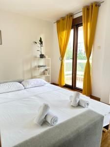 a bedroom with a white bed with towels on it at Sunny Studio Podgorica in Podgorica