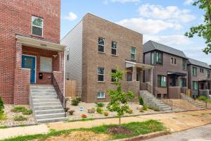a row of brick houses with stairs in front at Uptown Elegant Escape | JZ Vacation Rentals in Tower Grove