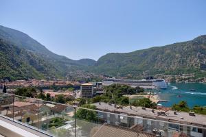 a view of a city and a river with mountains at Berge Apartments in Kotor
