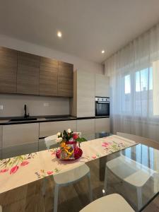 a kitchen with a table with flowers on it at Assisi Suite Apartment con annessa Tavernetta La Lavanda in Santa Maria degli Angeli