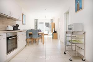 Una cocina con electrodomésticos blancos y una mesa con sillas. en Ferienwohnung Fördekönig, en Laboe