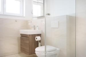 Un baño blanco con inodoro y lavabo. en Ferienwohnung Fördekönig, en Laboe 7 fotos más