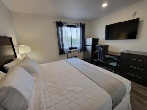 Una habitación de hotel con una cama grande y un escritorio. en The Suite Inn Minot, en Minot