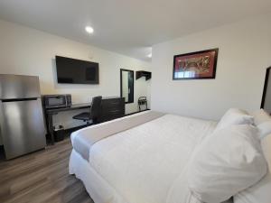 a hotel room with a bed and a desk at The Suite Inn Minot in Minot
