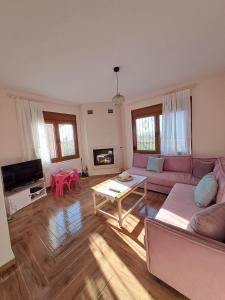 a living room with a pink couch and a table at Sea View Maisonette just 250m from the Beach Fully Equipped & Spacious! in AgiaKampos