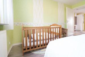 a baby crib in a room with green walls at Fewo Kuhnert in Laboe