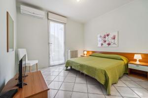 a bedroom with a bed and a television in it at Green Village Accommodations in Colico