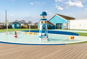 a playground with a toy lighthouse in the water at Stay static Hayling island holiday park in South Hayling