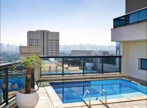 Un balcón con piscina en un edificio. en Luxuoso Flat Itaim, en São Paulo