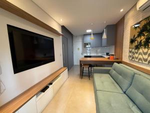 Una sala de estar con un sofá y un televisor de pantalla plana. en Luxuoso Flat Itaim, en São Paulo