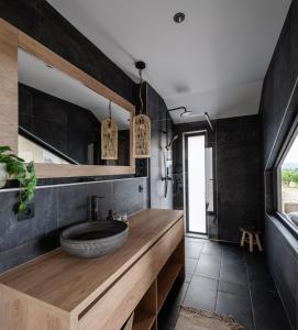 baño con encimera de madera y lavamanos en Kosa Estate, en Nána
