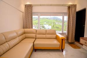 YedapalliにあるSinnis Homestay Ooty by LexStaysのソファと大きな窓のあるリビングルーム