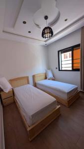 Un dormitorio con dos camas en una habitación. en Wino Surf House, en Imsouane