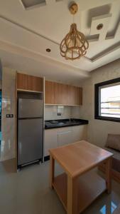 cocina con mesa, nevera y lámpara de araña en Wino Surf House, en Imsouane