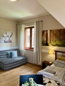 a living room with a couch and a bed at POKOJE GOŚCINNE Złote Modrzewie in Duszniki Zdrój