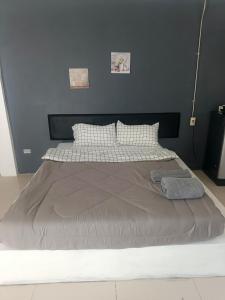 1 cama grande en un dormitorio con una pared azul en Mata's home, en Pattaya South 10 fotos más