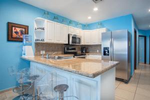 a kitchen with white cabinets and a stainless steel refrigerator at Happy-N-The-Sun 2 BR Oceanfront in Puerto Peñasco