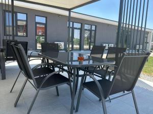 a glass table and chairs on a patio at Casa WEEK Dunare in Baziaş