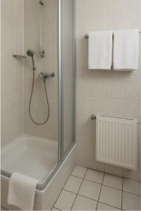 Un baño con ducha con puerta de cristal. en HOTEL Am Ratshof, en Halle an der Saale 121 fotos más