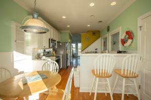 a kitchen with a wooden table and chairs and a kitchen with green walls at 867 Bonito Rd in Fripp Island
