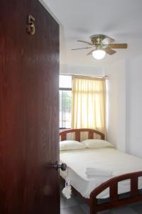 a bedroom with a bed and a ceiling fan at Hospedaje Los Organos in Los Órganos