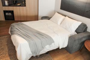a bedroom with a large bed with a chair and a bed sqor at HOM l Departamento 4PAX en Barrio Lastarria in Santiago +12 photos