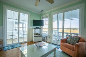 a living room with a couch and a table and windows at 867 Bonito Rd in Fripp Island