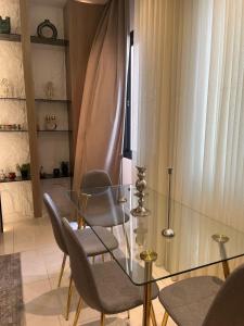 ein Esszimmer mit Glastisch und Stühlen in der Unterkunft شقة فاخرة مع إطلالة مركزية بالقرب من الحرم والخدمات in Medina