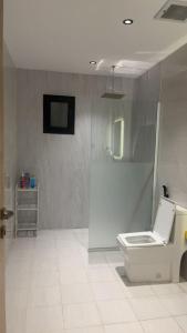 ein Bad mit WC und ein TV an der Wand in der Unterkunft شقة فاخرة مع إطلالة مركزية بالقرب من الحرم والخدمات in Medina