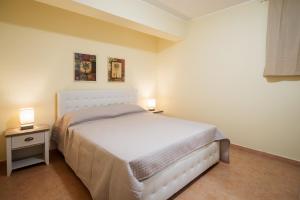 una camera da letto con un letto bianco e due comodini di MIlly House a Letoianni