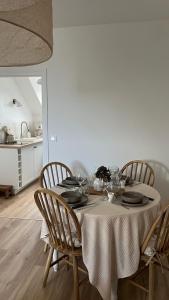 einen Esstisch mit Stühlen und einem Tischtuch in der Unterkunft Le Petit Cottage - Appartement Centre-Ville & Plage in Concarneau