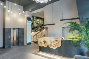 里加Aparthotel Aurum的大厅里有柜台，楼梯上种满了植物
