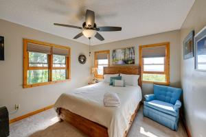 a bedroom with a bed and a ceiling fan and a blue chair at Yellow Mountain Vista Echoes at 4400 in Cullowhee