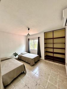 坎昆Bella casa centrica en Cancún para 6 personas的有两张床和一扇窗户的卧室