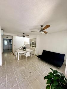 坎昆Bella casa centrica en Cancún para 6 personas的客厅配有桌子和吊扇